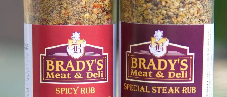 A close-up photo of two jars of Brady's Meat & Deli spice rubs: Spicy Rub and Special Steak Rub.