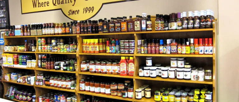 Four grocery shelves of high-quality sauces, jams, mustards, soups, and oils at Brady's.