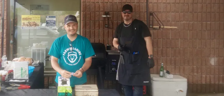 Mike Farwell accpeting donations at a charity BBQ in front of the Brady's shop